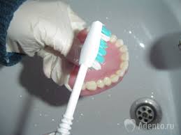 Photo: Nettoyage d'une prothèse avec une brosse à dents